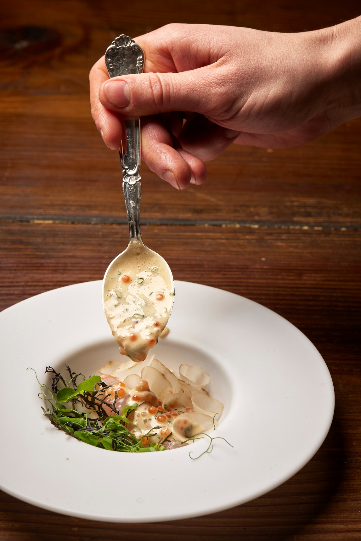 Grillet ret med urter på mørk tallerken, serveret hos Restaurant Grim